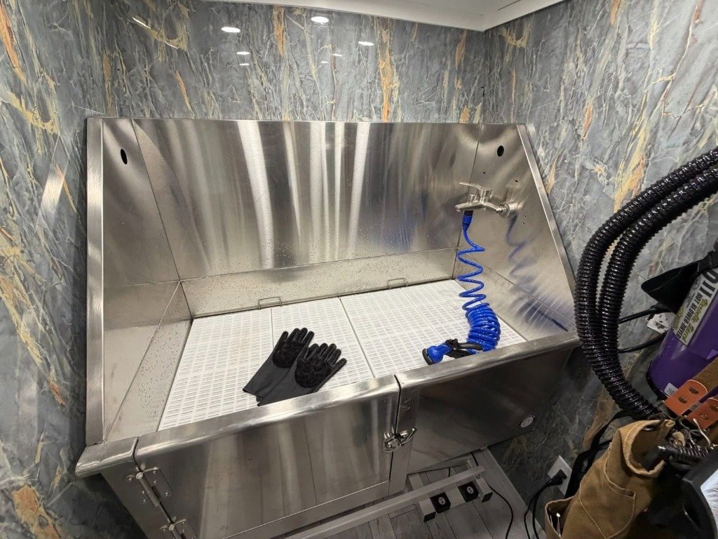 Professional stainless steel grooming tub inside the van